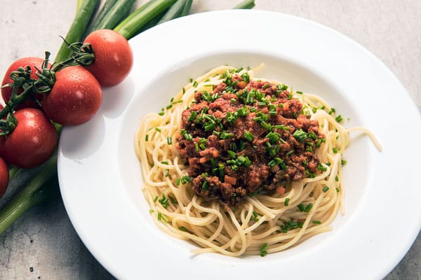 Hausgemachte Spaghetti Bolognese nach traditionellem Familienrezept mit frisch geriebenem Parmesan im Ristorante Alitalia Hamburg.